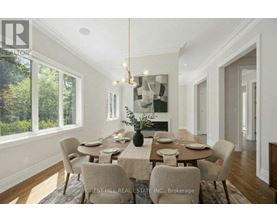 A dining room with a table set for six with a chandelier hanging above it.