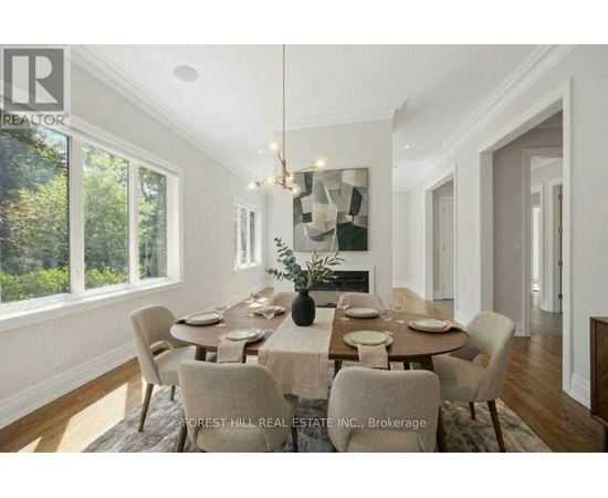 A dining room with a table set for six with a chandelier hanging above it.