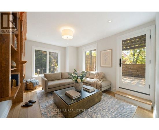 A living room with a couch, coffee table, and a painting on the wall.