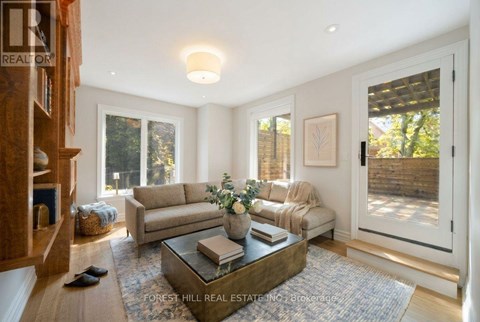 A living room with a couch, coffee table, and a painting on the wall.