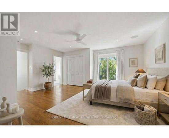 A bedroom with a bed, a plant, and a fan.