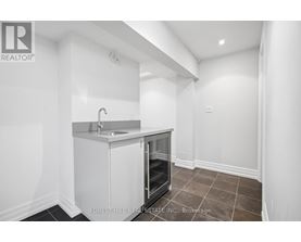 A small white kitchen with a sink and a refrigerator.