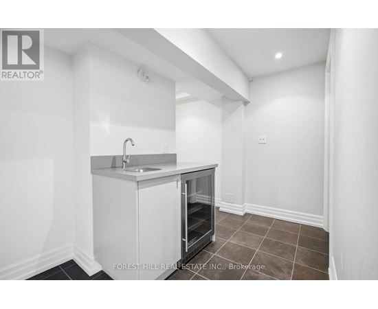 A small white kitchen with a sink and a refrigerator.