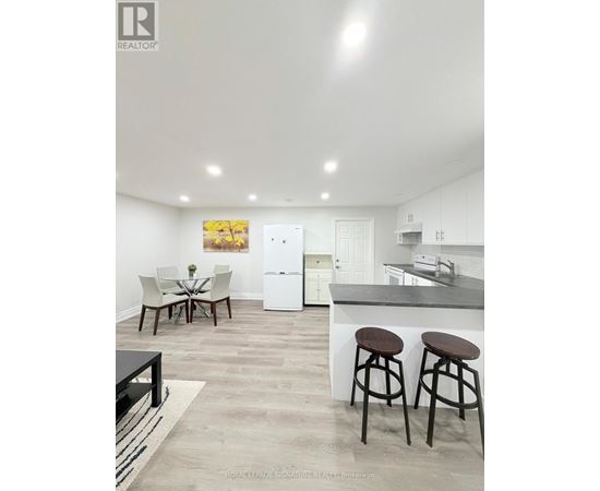 A modern kitchen with white cabinets and a black countertop.