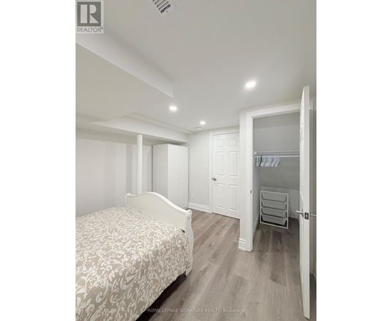A bedroom with a bed, wardrobe and a dresser.