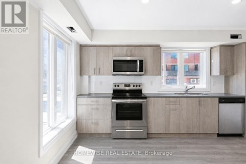 A modern kitchen with a stove top oven and microwave above the counter.
