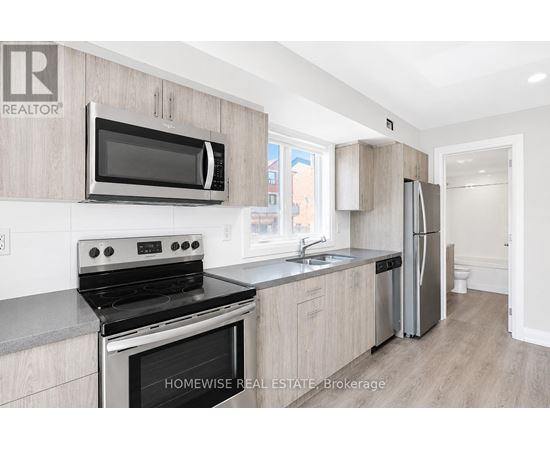 A kitchen with a stove, microwave, and refrigerator.