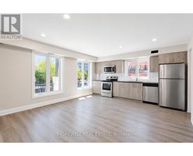 A spacious kitchen with stainless steel appliances and wooden cabinets.