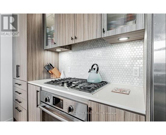 A modern kitchen with a stove top and wooden cabinets.