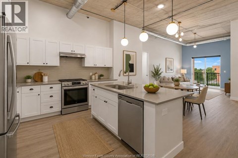 A modern kitchen with white cabinets and stainless steel appliances.