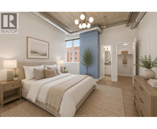 A bedroom with a large bed, a nightstand, and a plant.