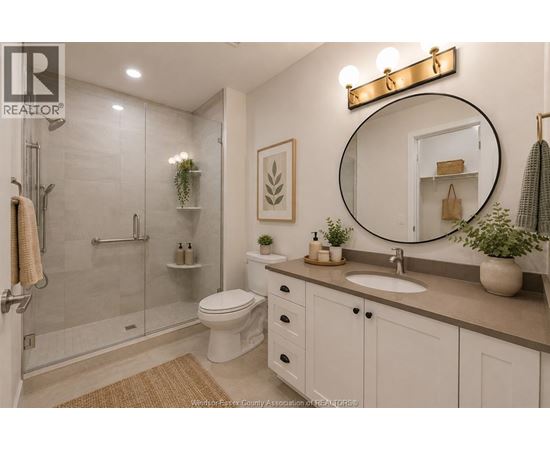 A bathroom with a toilet, sink, mirror, and shower.