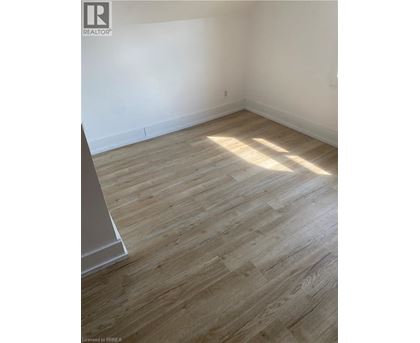 A room with wooden flooring and white walls.