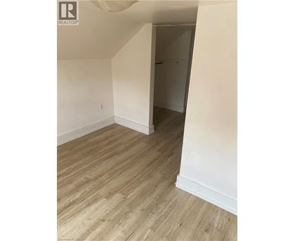 A room with wooden flooring and white walls.