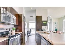 A modern kitchen with a large island and a sign that says "HOME".