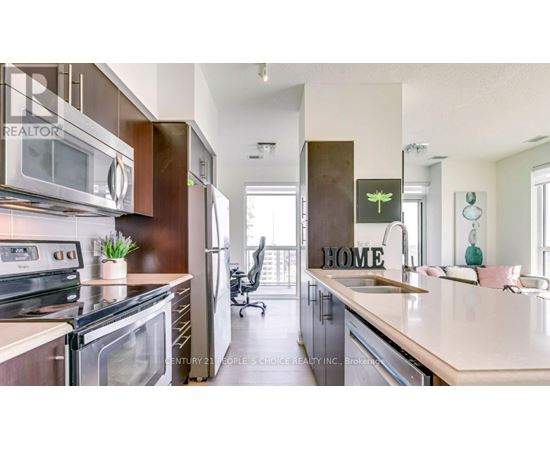 A modern kitchen with a large island and a sign that says "HOME".