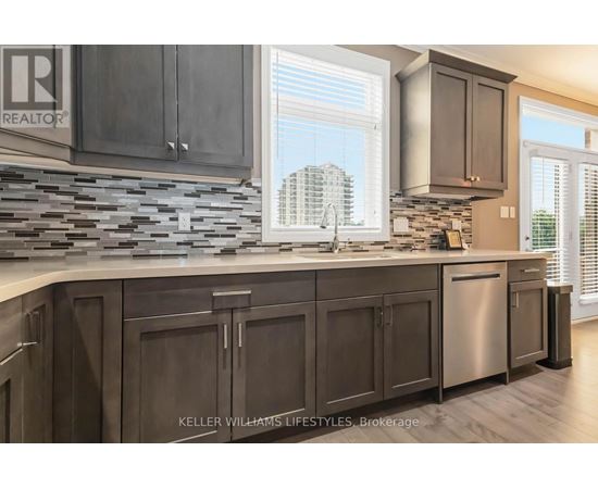 A kitchen with dark wood cabinets and a stone backsplash.