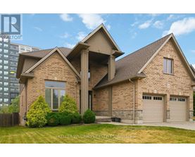 A house with a stone facade and a large driveway is for sale.