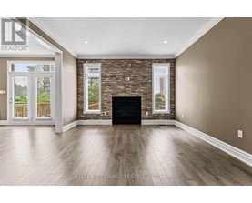 A spacious living room with a stone fireplace and hardwood floors.