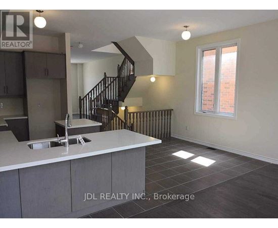 A kitchen with a sink and a staircase.