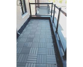 A balcony with a black railing and a tiled floor.