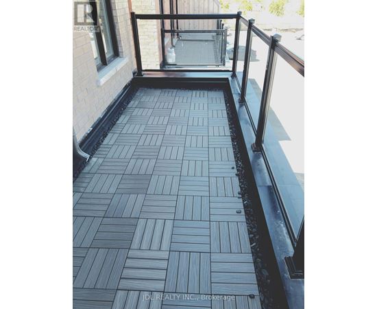 A balcony with a black railing and a tiled floor.