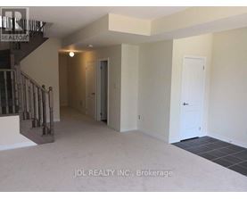 A spacious room with a staircase and two doors.