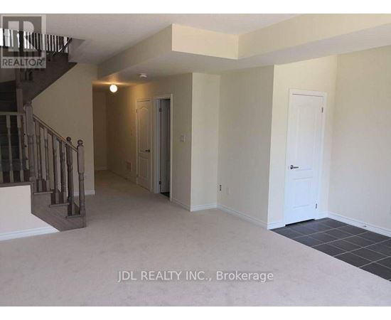 A spacious room with a staircase and two doors.