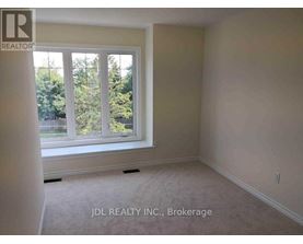 A room with a window showing trees outside.