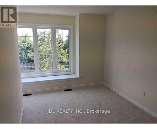 A room with a window showing trees outside.