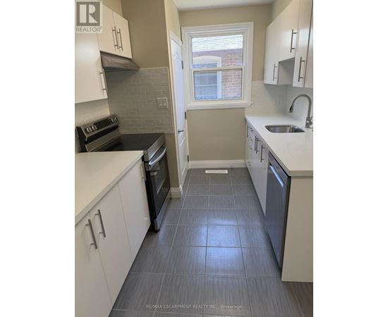A kitchen with white cabinets and a black oven.