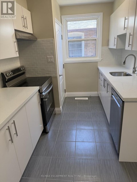 A kitchen with white cabinets and a black oven.