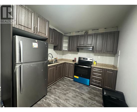 A kitchen with a black refrigerator and a black chair.