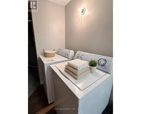 A laundry room with a washer and dryer, a basket, and towels.