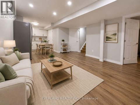 A living room with a couch, coffee table, and a painting on the wall.