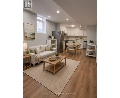 A well-lit, modern kitchen and living room with wooden floors and furniture.