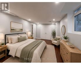 A bedroom with a large bed, a chair, and a painting on the wall.