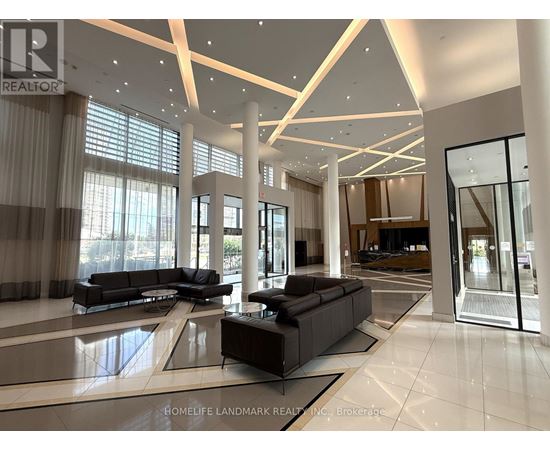 A spacious living room with a black sofa set and a glass door.