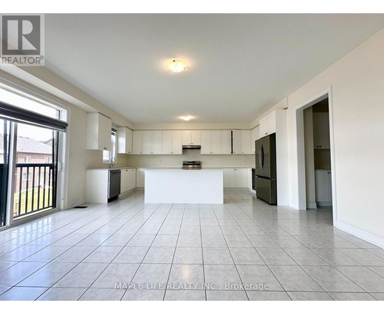 A spacious kitchen with white cabinets and a large island in the middle.