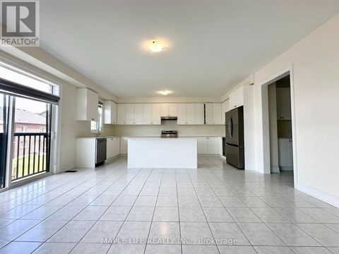 A spacious kitchen with white cabinets and a large island in the middle.