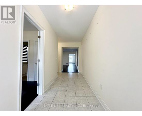 A long hallway with a door on the left and a window on the right.