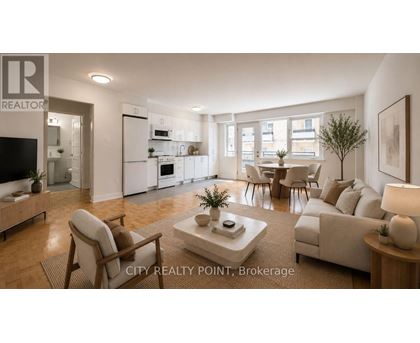 A well-lit, spacious living room with a dining area in the background.