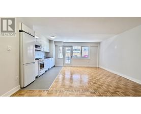 A kitchen with white appliances and wooden floors.