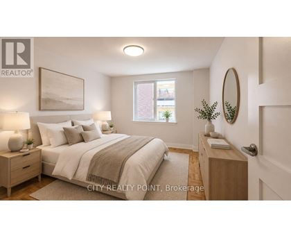 A well-lit bedroom with a large bed and a nightstand with a lamp.