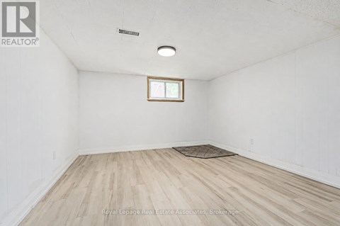 A room with a window and wooden flooring.