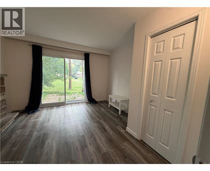 A room with a sliding glass door leading to a garden.
