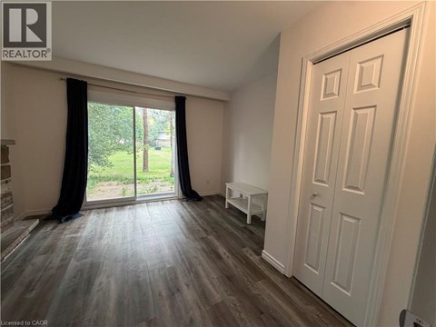 A room with a sliding glass door leading to a garden.