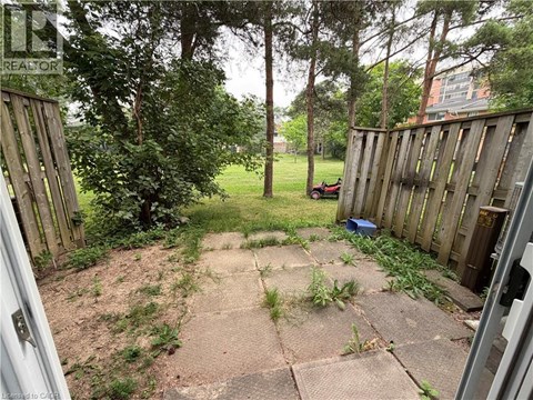 A backyard with a wooden fence and a concrete patio.