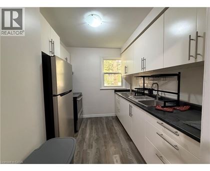 A kitchen with white cabinets and a black countertop.