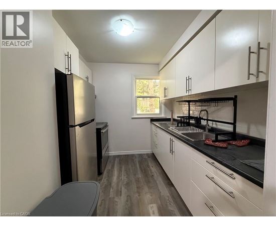 A kitchen with white cabinets and a black countertop.